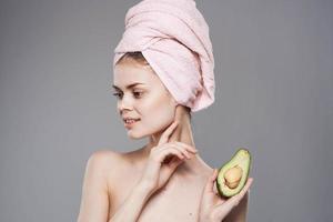 Elegant woman holding a pink towel on her head in her hand Exotics fruits clean skin cosmetics photo