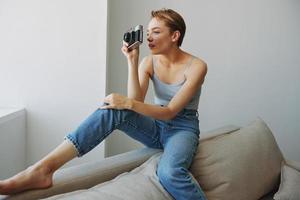 Woman photographer shooting in studio on old film camera at home on couch portrait, white background, free copy space, freelance photographer photo