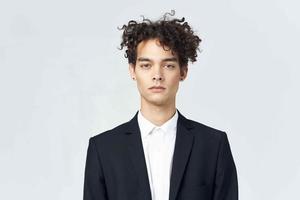 business man with curly hair in suit black blazer studio photo