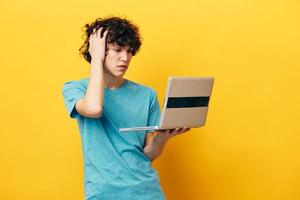 student in blue t-shirts with laptop internet yellow background photo