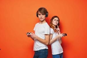 young couple in white t-shirts with joysticks in hands playing entertainment photo