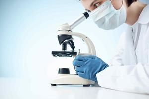 mujer en laboratorio mirando mediante microscopio de cerca biotecnología Ciencias foto