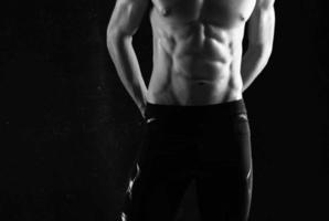 man with pumped up abs exercises motivation dark background photo