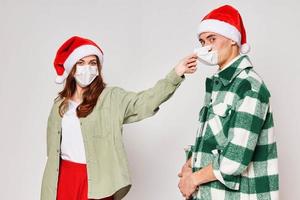 young couple wearing medical masks protecting new year holiday together photo