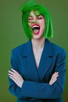 Portrait of a charming lady wearing a green wig blue jacket posing green background unaltered photo