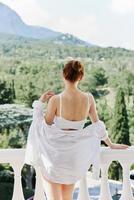 Portrait of a beautiful woman in lingerie on the balcony beautiful view from the window sunny day photo