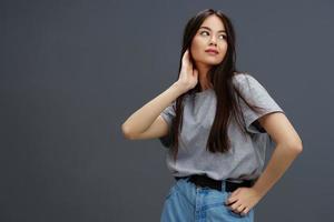 joven mujer en un camiseta y pantalones posando juventud estilo gris antecedentes foto