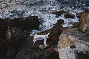 beautiful young woman lying on rocky coast with cracks on rocky surface Summer vacation concept photo