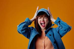 bonito mujer en un gorra y mezclilla chaqueta posando estudio modelo inalterado foto