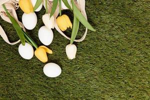 bouquet of tulips Easter eggs lie on green grass Copy Space decoration photo