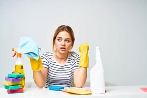 cleaning lady sitting at the table washing supplies work pallets light background photo