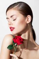 Woman with flower Eyes closed rose in the hands of luxury photo