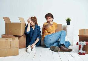 Moviente renovación contento hombre y mujer en el piso en un nuevo Departamento con cajas foto