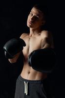 bodybuilders boxing gloves on black background and gray pants photo