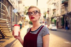 pretty short haired woman drinking cup outdoors photo