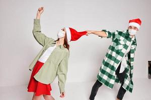 un hombre sostiene un mujer por un sombrero Navidad fiesta nuevo año médico máscara foto