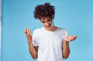 indignant guy with a comb in curly hair on a blue background Copy Space photo