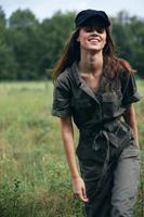 Woman in the meadow In a green jumpsuit black cap smile travel photo