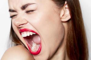 Close-up woman with wide open mouth and closed eyes photo