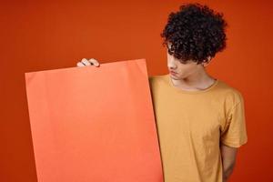 man with curly hair holding a poster in hands Copy Space cropped view photo