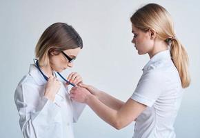 Doctor and patient on light blue background stethoscope health problems cropped view photo