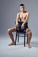 handsome athletic man sits on a chair inflated body photo