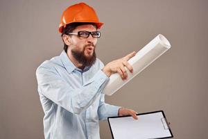 Cheerful man orange hard hat documents professional blueprints construction photo