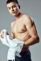 cute guy with pumped up body towel in hand workout cropped view photo