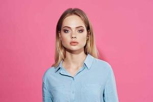 pretty blonde in blue shirt cosmetics pink background photo