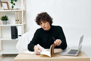 man sitting on the couch at the table in front of a laptop communication photo