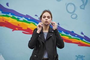 mujer cerca el pintada en el pared en el formar de un arco iris en el calle foto