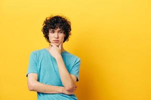 Cheerful teenager in a blue t-shirt on a yellow background photo