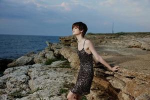 bonito mujer con corto pelo al aire libre piedras glamour posando foto