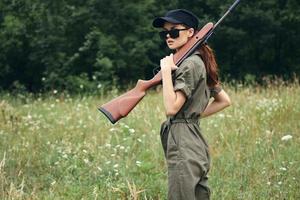 Woman weapon in hands jumpsuit hunting weapons green photo