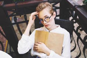 female with glasses outdoors in a summer cafe rest education photo