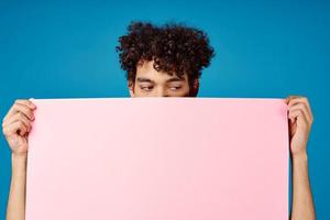 guy with curly hair holding pink Poster mockup Coffee Space photo