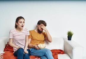 man and woman on sofa orange plaid bright room flower in a pot photo