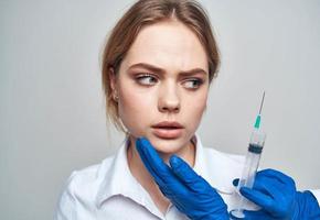 mujer jeringuilla anestesia botox inyección médico azul guantes foto