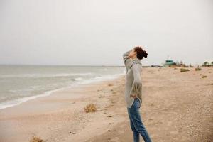 portrait of a woman cloudy weather by the sea travel fresh air Happy female relaxing photo