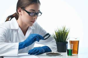 Woman in white coat examines plants microbiology photo