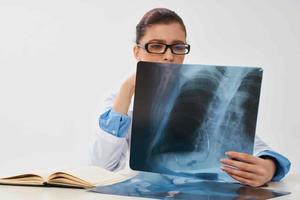 médico con radiografía se sienta a el mesa diagnósticos tratamiento foto