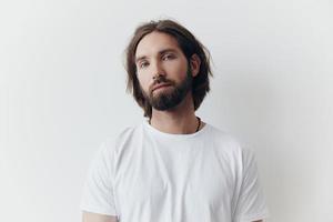 Portrait of a man with a black thick beard and long hair in a white T-shirt on a white isolated background lifestyle without pathos everyday image photo