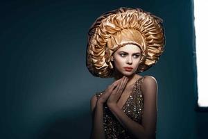 bonito mujer en grande dorado sombrero Clásico estilo de vida glamour foto