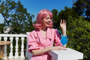 Delighted young girl in pink dress outdoors with cocktail Summer day photo