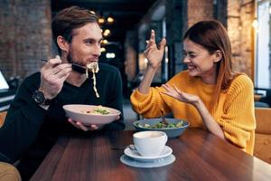 young couple sitting in a restaurant chatting dating photo