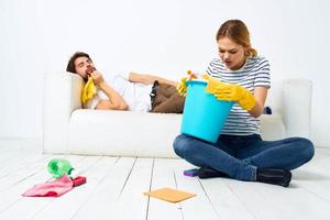 The husband lies on the couch while his wife cleans up the interior work photo