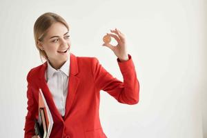 woman in a red jacket with documents in hand light background photo