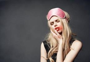 Drunk blonde with pink sleep mask smears lipstick all over her face photo