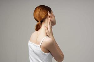 mujer en blanco camiseta participación en a el cuello salud problemas articulación ligero antecedentes foto