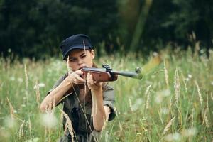 mujer en al aire libre sentado en el césped arma en el manos de un visión caza Fresco aire foto